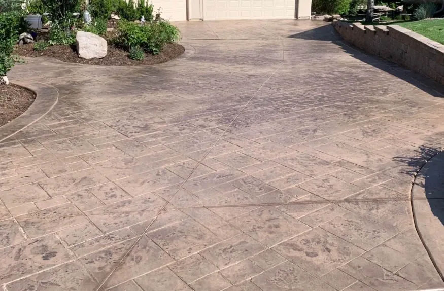 Stamped concrete driveway with a tan flagstone pattern pressed into the slab
