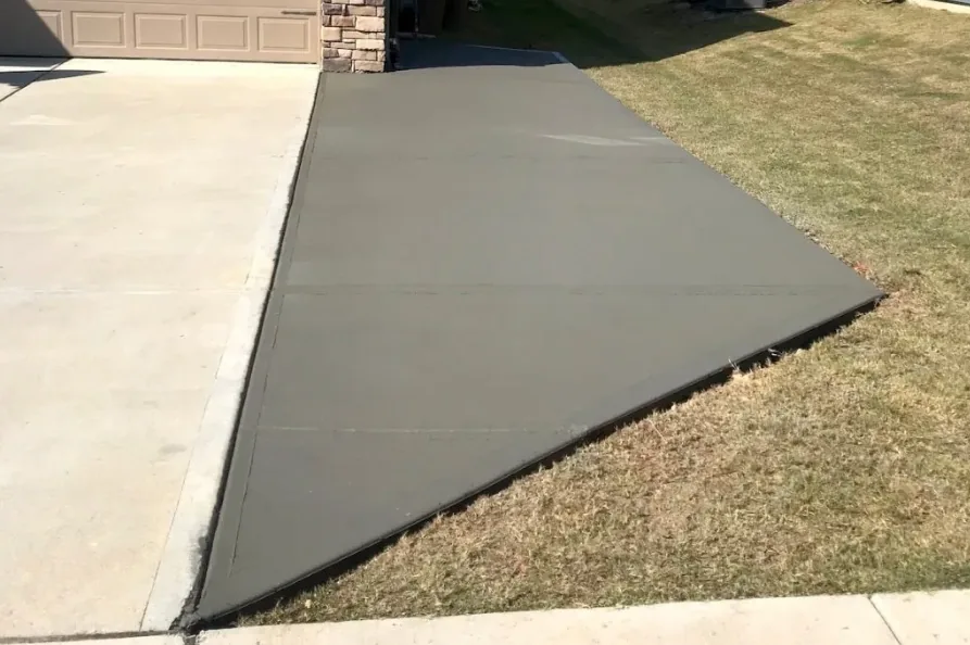 Concrete driveway extension widening an existing drive toward the street