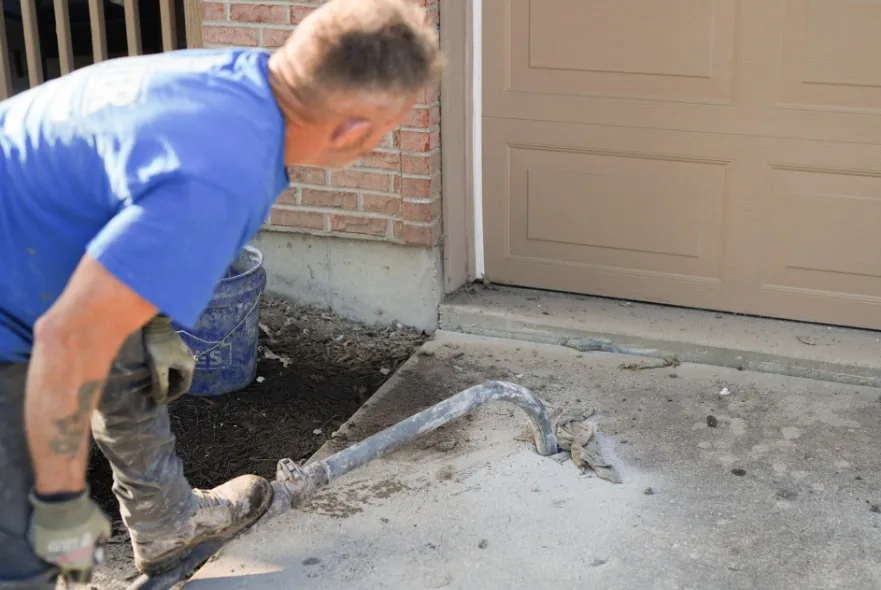 Material being pumped beneath a settled concrete slab to lift it back to grade
