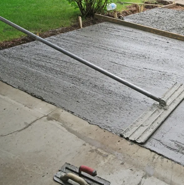 Concrete driveway section being patched and screeded during a repair