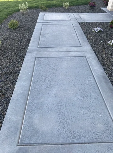 Concrete walkway panels running between a house and a fence line